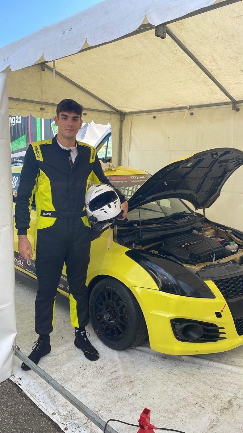 Eszenyi Mór a sisakjával a #518 Suzuki mellett a boxban